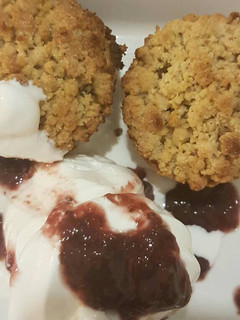 A picture of Apple crumble with vanilla ice cream and cranberry sauce.