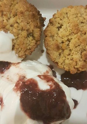 A picture of Apple crumble with vanilla ice cream and cranberry sauce.