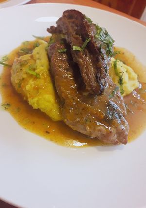 Una foto de Cerdo en su salsa, sobre hummus de garbanzo al curry