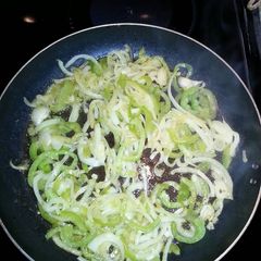 A picture of Sauteed onions and green peppers with hamburger meat or hot dogs.