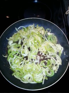 A picture of Sauteed onions and green peppers with hamburger meat or hot dogs.