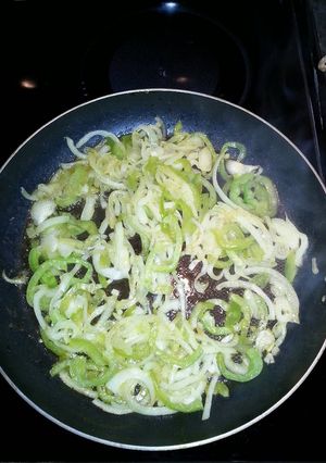 A picture of Sauteed onions and green peppers with hamburger meat or hot dogs.