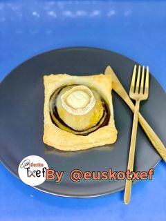 Una foto de Hojaldre de berenjena con pera encebollado y corona de cabra