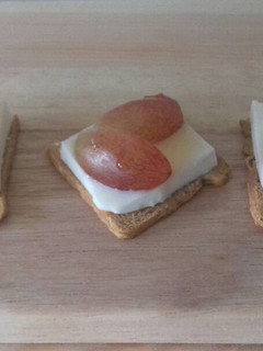 Una foto de Canapés de queso fresco, uva negra y miel