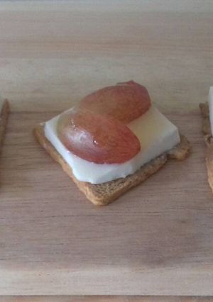 Una foto de Canapés de queso fresco, uva negra y miel