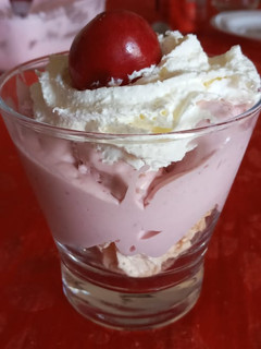 Una foto de Postre en vaso de merengue, helado de frambuesa y crema chantilly