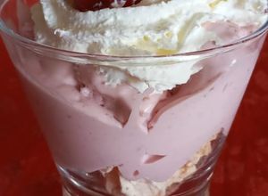 Una foto de Postre en vaso de merengue, helado de frambuesa y crema chantilly