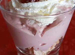 Una foto de Postre en vaso de merengue, helado de frambuesa y crema chantilly