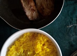 Une photo de Bananes Plantain Bouillies, Steak de Porc et Riz au Curcuma