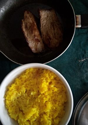 Une photo de Bananes Plantain Bouillies, Steak de Porc et Riz au Curcuma