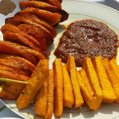 A picture of Palm oil fried yam,plantain with tomatoes sauce.