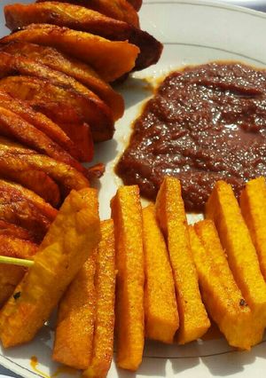A picture of Palm oil fried yam,plantain with tomatoes sauce.