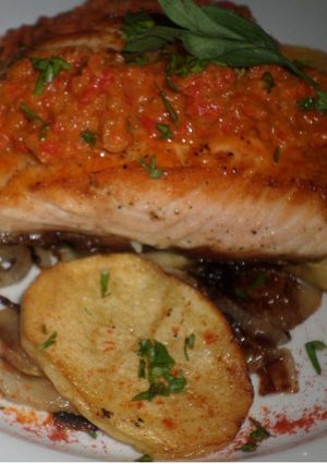 Una foto de Salmon a la vizcaína en colchón de papa y cebolla