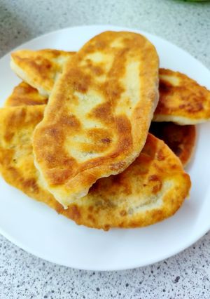 Фото Жареные пирожки на сковороде с печенкой и мясом.