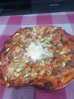 Una foto de Pizza de jamón huevo y calabacín