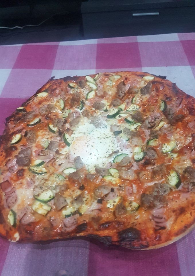 Una foto de Pizza de jamón huevo y calabacín