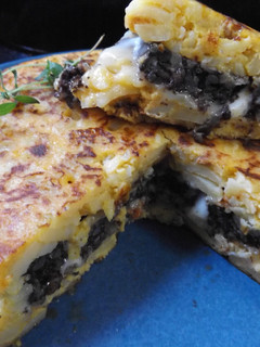 Una foto de Tortilla de patatas y chorizo rellena con morcilla de Burgos y queso