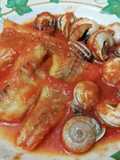 Filetes de pescado y caracoles con salsa de tomate