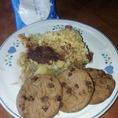A picture of Pineapple crumble with yogurt and chocolate cookies.