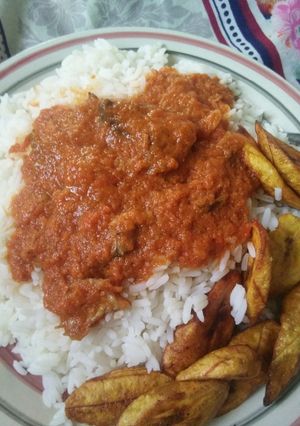 A picture of Rice, stew and fried plantain.