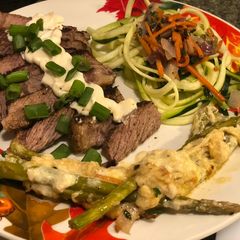 A picture of Seared Ribeye, Cheesy Baked Asparagus, with Zoodle Medley.
