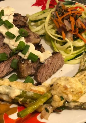 A picture of Seared Ribeye, Cheesy Baked Asparagus, with Zoodle Medley.