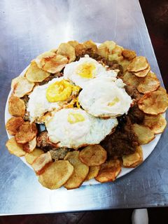 Una foto de Milanesa al horno a caballo con papas chips