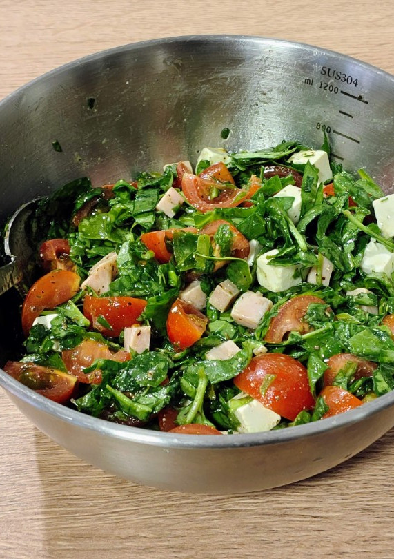 Una foto de Ensalada del día: con espinacas, pavo salteado, tomates cherry y queso feta