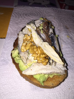 Una foto de Tostada de aguacate, anchoas, boquerones, nueces y aceite de oliva