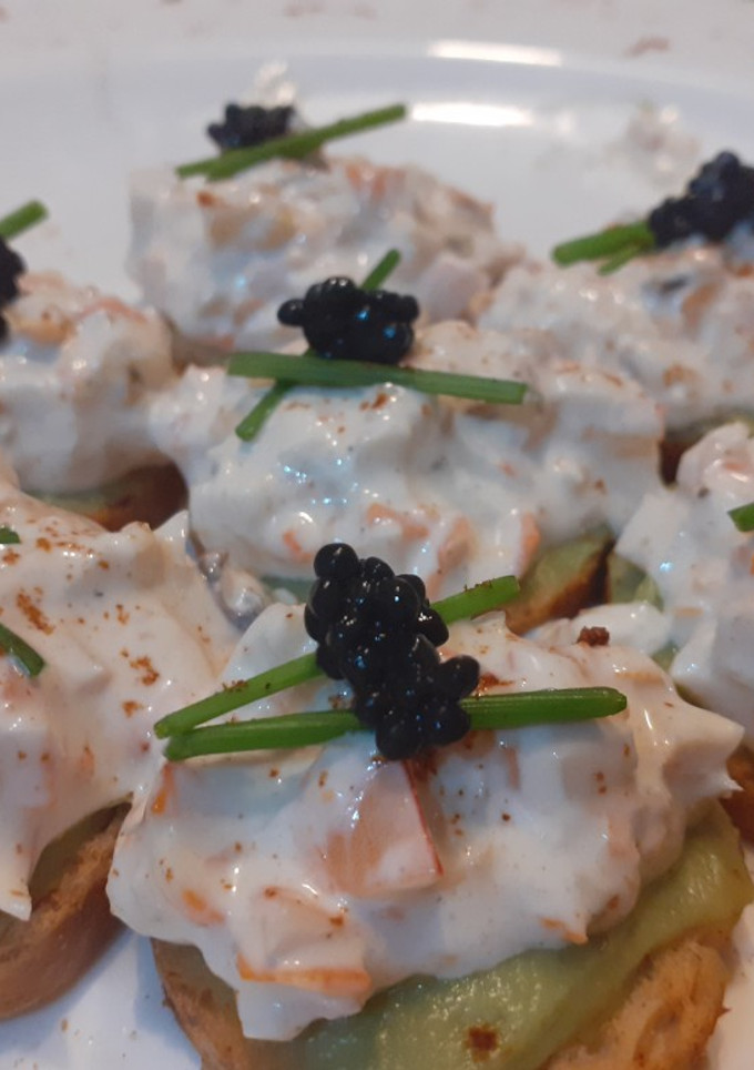 Una foto de Tostas de aguacate y marisco