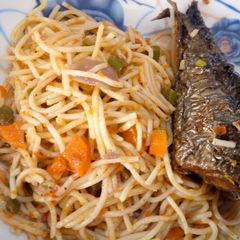 A picture of Festive spaghetti with fried mackerel fish.