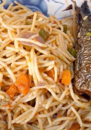 A picture of Festive spaghetti with fried mackerel fish.