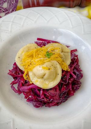Foto di Tortelli alla zucca su cavolo rosso (viola) in agrodolce