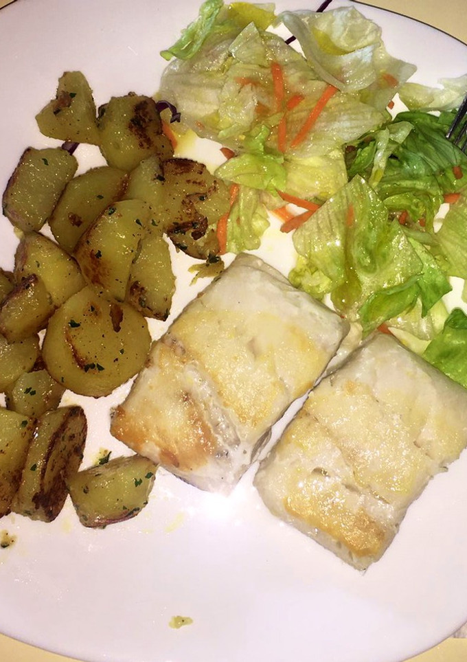 Una foto de Merluza a la plancha con ensalada y patatas guarnición