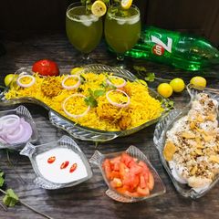 A picture of Chicken biryani,Meethe dahi baray and Mint Drink.
