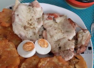 Una foto de Pollo con queso gratinado patacón y ensalada de guacamole