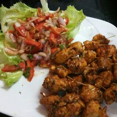 A picture of Chicken tikka with salad.