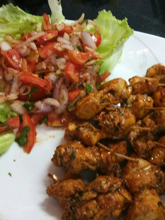 A picture of Chicken tikka with salad.