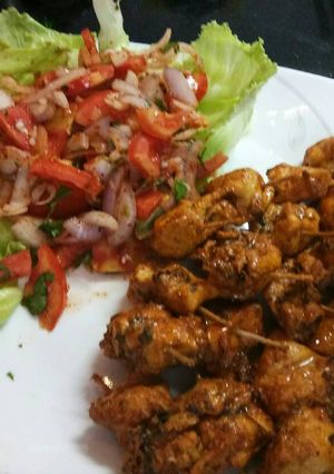 A picture of Chicken tikka with salad.