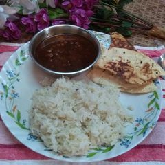 A picture of Brown chana,jeera rice without oil and roasted papad.