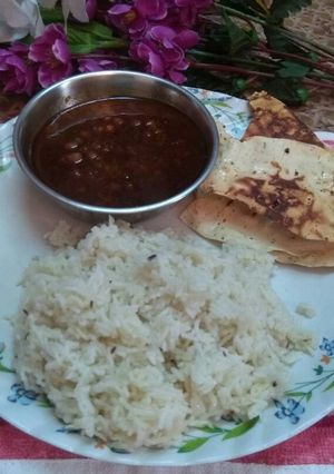 A picture of Brown chana,jeera rice without oil and roasted papad.
