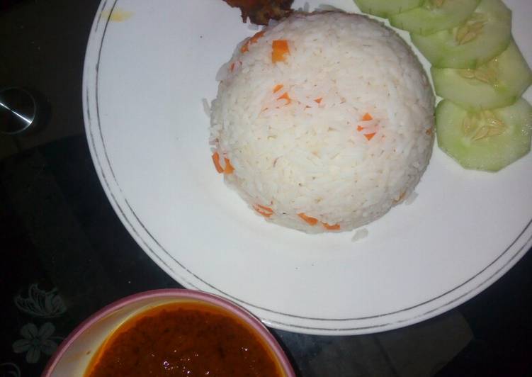 White rice and stew garnished with carrots and cucumber