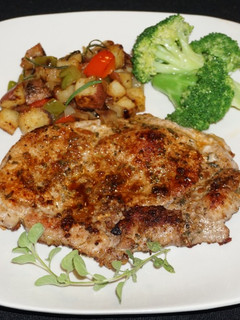 Una foto de Chuletas de chancho al orégano con papas salteadas y brócoli