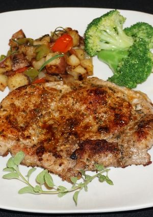 Una foto de Chuletas de chancho al orégano con papas salteadas y brócoli