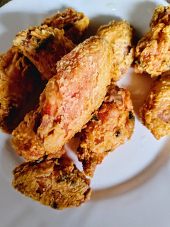 Una foto de Alitas y muslitos de pollo fritos
