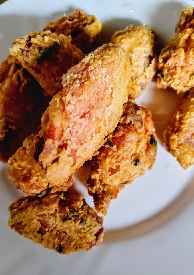 Una foto de Alitas y muslitos de pollo fritos