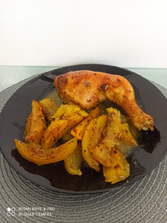 A picture of Chicken Thighs with Potatoes in the Oven.