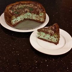 A picture of Mint Chococolate Chip Cheesecake with a Fudge Brownie Crust.