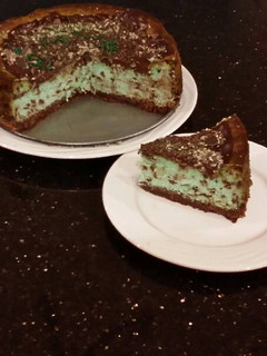 A picture of Mint Chococolate Chip Cheesecake with a Fudge Brownie Crust.