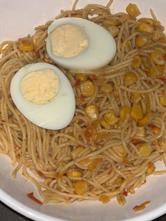 A picture of Corn spaghetti with hard boiled egg.